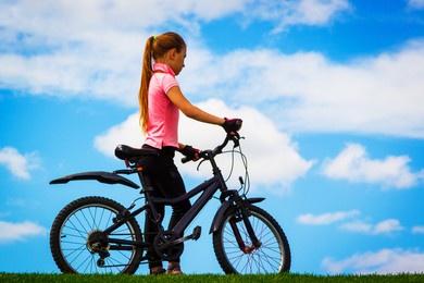 girl with a bicycle against the sky.