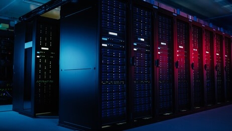 shot of data center with multiple rows of fully operational server racks. modern telecommunications, artificial intelligence, supercomputer technology concept. shot in dark with neon blue, pink lights