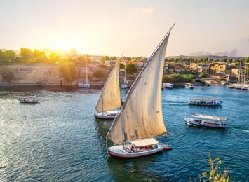 river nile and boats at sunset in aswan