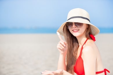 summer sunblock concept - beauty asian woman apply the sunscreen lotion