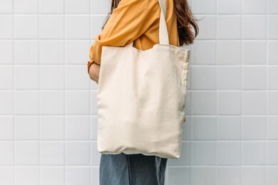 woman is holding tote bag canvas fabric for mockup blank template.