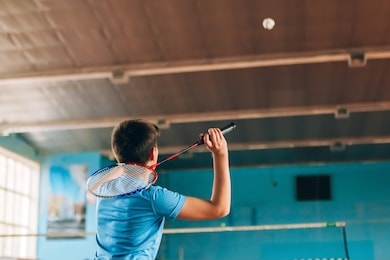 badminton court with players. tennis player with a racket. badminton activity. sports game of success. happy kid playing badminton. the child beats the shuttle with a racket.