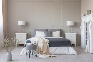 new york style bedroom interior with symmetric design, copy space on empty grey wall