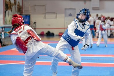  two girls in blue and red taekwondo equipment are fighting at doyang 