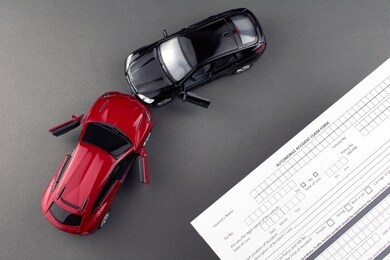 car crash broken cars and car insurance document. short term car insurance concept. gray background