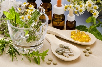 alternative medicine. rosemary, mint, chamomile, thyme in a glass mortar. essential oils and herbal supplements.