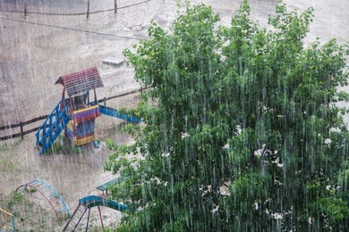 heavy rain against the tree and a children's playground