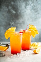 tequila sunrise cocktail with grilled pineapple and orange