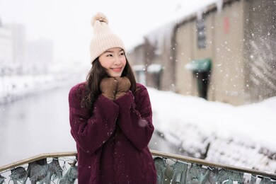 beautiful young asian woman smile and happy with travel trip at otaru canal hokkaido japan in snow and winter season