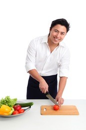 young chef wearing a white shirt and apron. preparing a salad. white background.