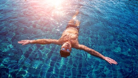 young athletic man swimming in the swimming pool. active sport