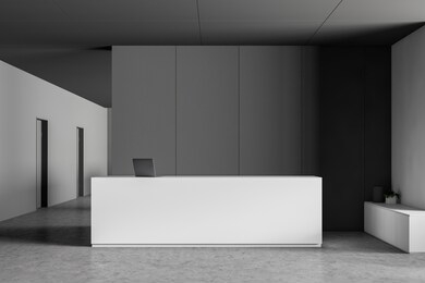 white reception desk with laptop computer on it standing in modern office lobby with gray and white walls and concrete floor. 3d rendering
