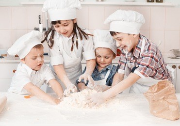 happy little chefs preparing dough in the kitchen