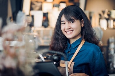 asian woman barista making hot coffee with machine at counter bar and smile at camera in cafe restaurant,food and drink service concept.