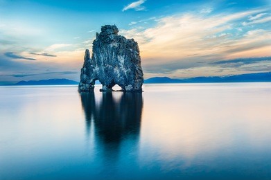 hvitserkur is a spectacular rock in the sea on the northern coast of iceland. legends say it is a petrified troll. on this photo hvitserkur reflects in the sea water after the midnight sunset.