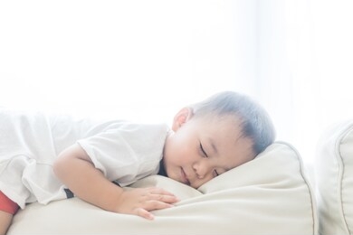 toddler boy sleeping in sofa and dream.asian 2 years old baby boy sleep on the sofa in living room.sleep time,comfortable, peaceful and growth hormone concept. 
