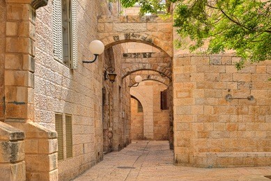 narrow cobbled street among traditional stoned houses of jewish quarter at old historic part of jerusalem, israel.