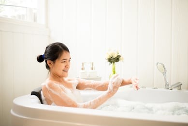 beautiful asian woman relaxing in bubble bathtub,female lying body in water