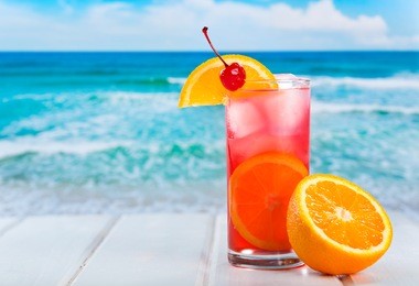 fruit cocktail with orange slice on a beach
