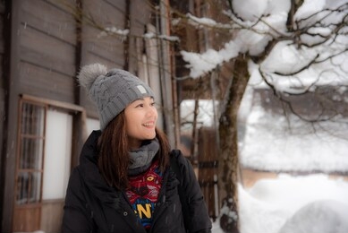 an young asian woman traveler smiles a female tourist in the shirakawago village during the winter in japan