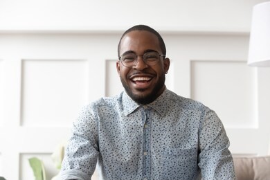 happy cheerful young black man video calling looking at camera at home, smiling african guy communicate in internet chat recording vlog talking laughing skyping enjoy online conversation, webcam view