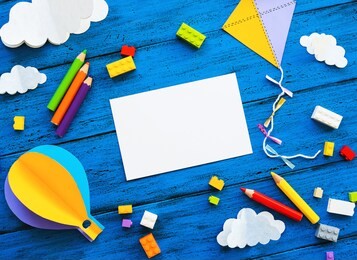 Сolourful toy bricks, paper crafts and blank card on blue wood board. school or preschool creative background. concept of diy, construction, adventure, playing child education or kids learn languages