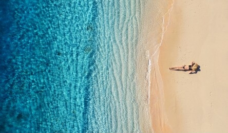 aerial view of a girl on the beach. vacation and adventure. beach and turquoise water. top view from drone at beach, azure sea and relax girl. travel and relax - image