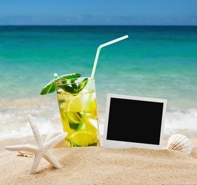 refreshing mojito cocktail on the sea sand with shells