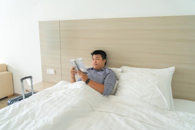 businessman reading book on bed for relaxation
