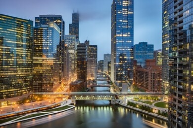 chicago downtown skyline taken at wolf point in a fantastic cloudy evening, with lights of the skyscrapers reflected in the chicago river, illinois, united states