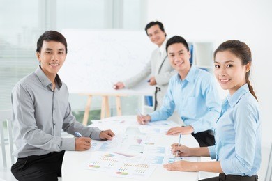 businesspeople sitting at the meeting and looking at camera