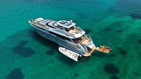 aerial drone photo of large yacht - boat docked in tropical exotic paradise bay with emerald open ocean