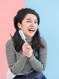 happy asian woman holding blue ice cream stick with color background.