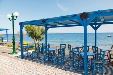 tables and chairs overlooking kamari beach santorini greece