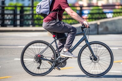 cyclist cycling pedals a bicycle and rides along a dedicated bicycle path preferring active healthy lifestyle and alternative eco-friendly transport in order to preserve the environment of his city