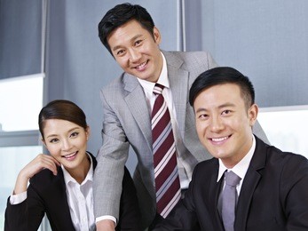 a team of asian business people looking at camera and smiling.