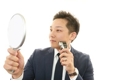 a man shaving with electric razor