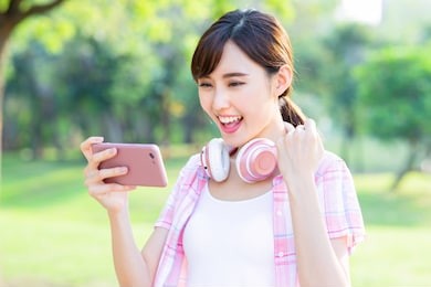 young asian girl play mobile game on her smart phone