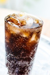 a glass of cola with ice cubes