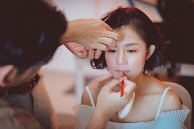  makeup artist working on beautiful asian model