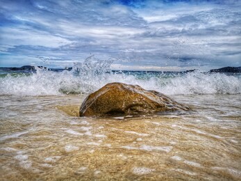 closeup with the sandy beach splashing water and swash wave in kota kinabalu, tanjung aru beach. sabah, malaysia.