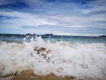 closeup with the sandy beach splashing water and swash wave in kota kinabalu, tanjung aru beach. sabah, malaysia.