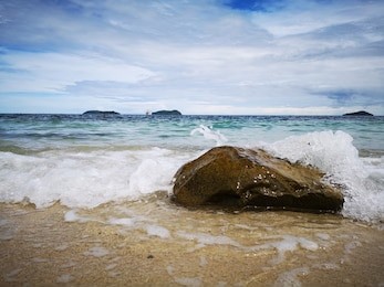 closeup with the sandy beach splashing water and swash wave in kota kinabalu, tanjung aru beach. sabah, malaysia.