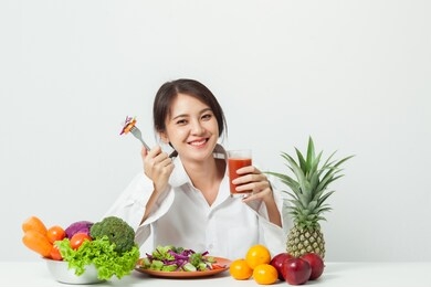 asian woman love vegetables and smiling on white background. healthy food and diet concept.