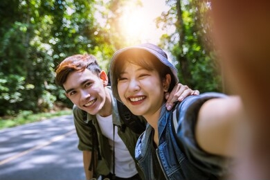 asian group of young people with friends and backpacks walking together and happy friends are taking photo and selfie ,relax time on holiday concept travel