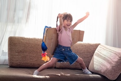 portrait of happy asian little child girl playing in an astronaut costume