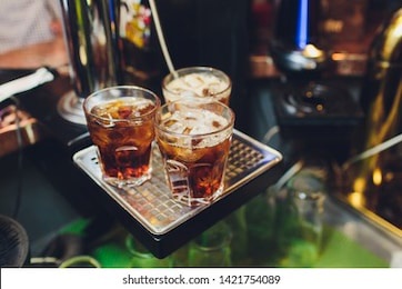 three cocktails on the bar. whiskey cola, rum cola, whiskey with juice on the bar during a nightclub party.