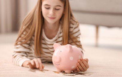 teen girl with piggy bank and money at home