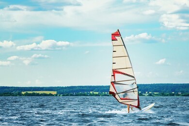 windsurfer catches the wind and cuts the waves while driving fast