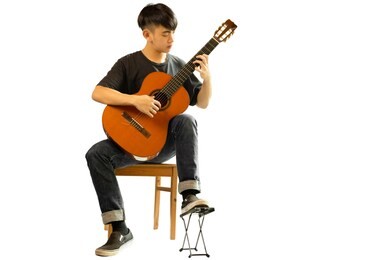 asian man playing a classic guitar isolated in white background.